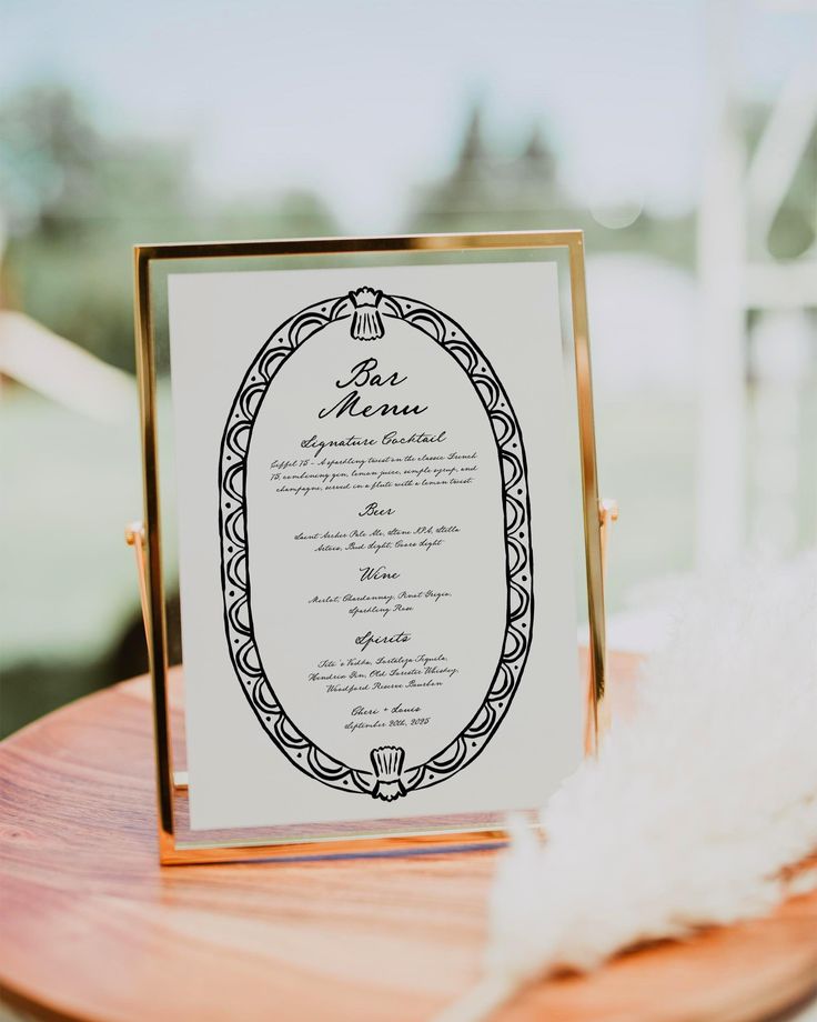 the menu card was placed on top of a wooden table with white feathers in front of it