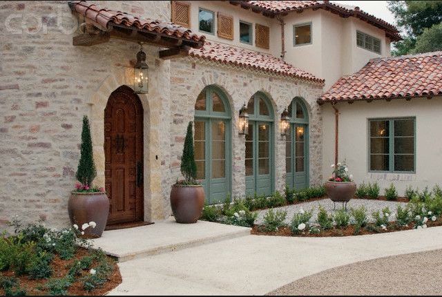 a house with two large planters in front of it and an entry way leading to the outside