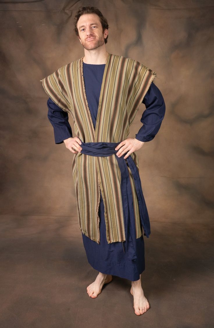 a man standing in front of a brown background wearing a blue and tan striped robe