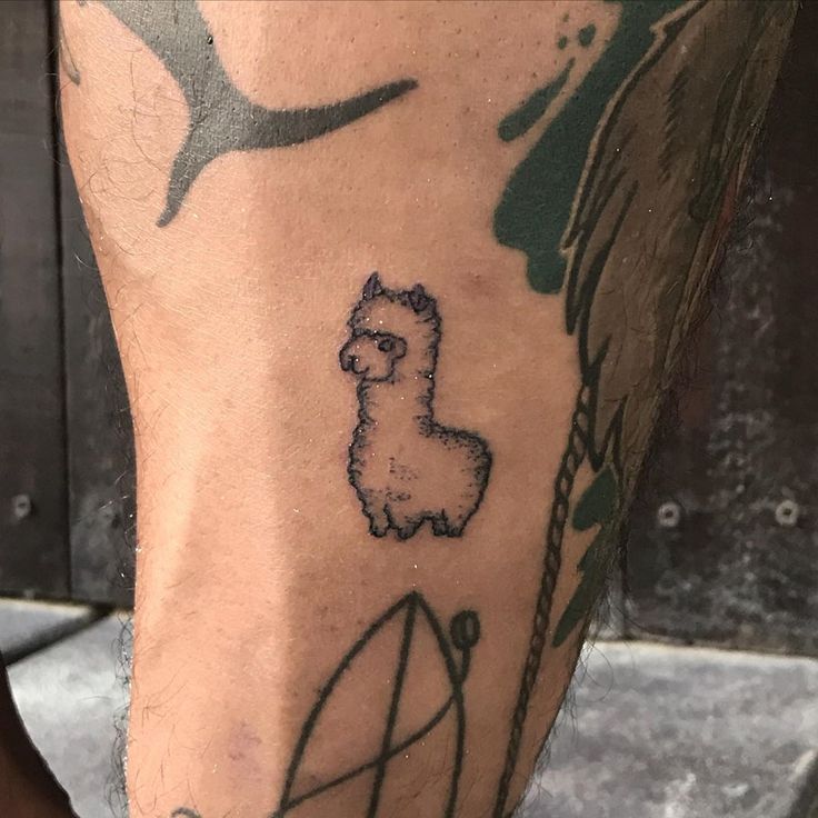 a man's leg with a tattoo on it that has an image of a llama