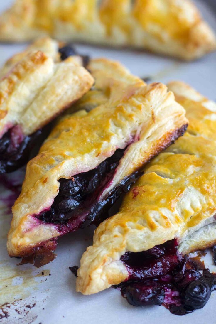 three blueberry pastries sitting on top of a white plate next to each other