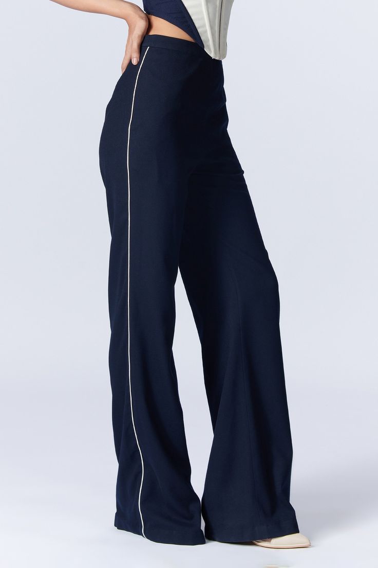 Navy wide legged trousers with side contrast piping details, side pockets and placement 'S&N' logo thread patch embroidery on waistband.
Components: 1
Pattern: Embroidered
Type Of Work: Thread Patch Work
Fabric: Poly Blend, Viscose, Lycra
Color: Blue
Other Details: 
Tailored trousers
Closure : Back concealed zip
Note: The jacket and inner corset worn by the model is not for sale
Occasion: Work,Party - Aza Fashions Navy Wide Leg Trousers, Wide Legged Trousers, Patch Embroidery, Work Party, Patch Work, Contrast Piping, Fashion App, Tailored Trousers, S N