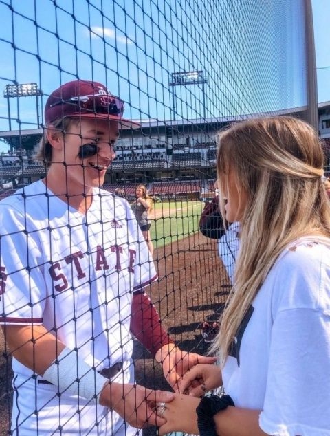 a baseball player is talking to a young woman