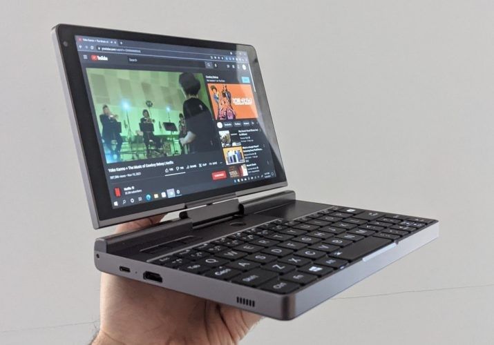 a person holding up a laptop computer in their hand