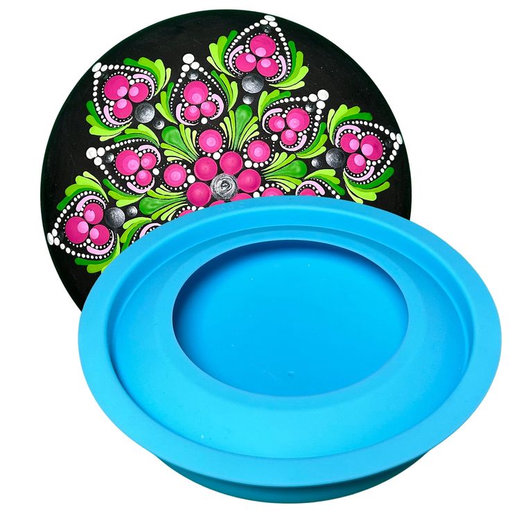 two frisbees sitting next to each other on a white surface with flowers painted on them