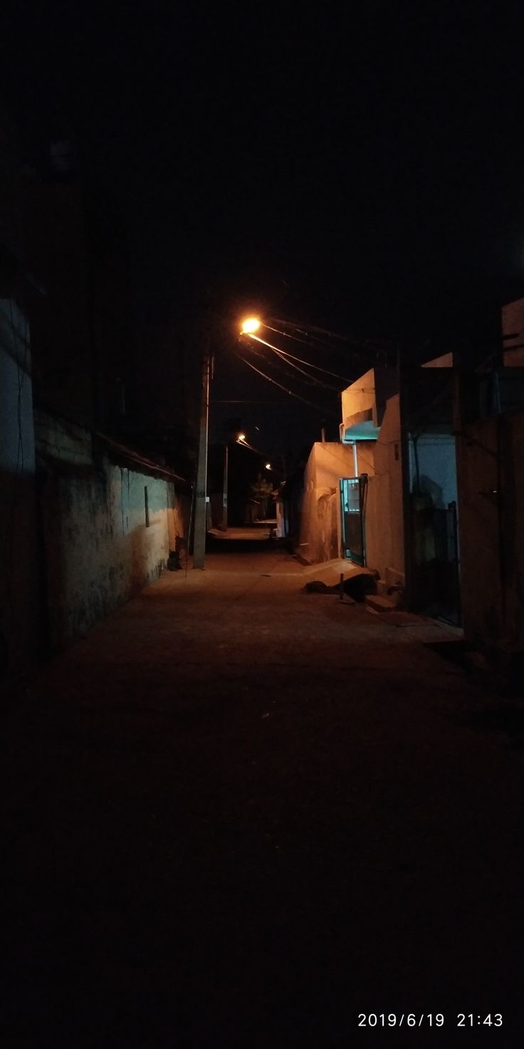 an alley way at night with street lights on