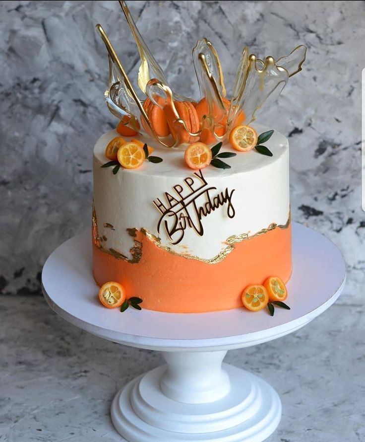 a birthday cake decorated with orange and gold decorations