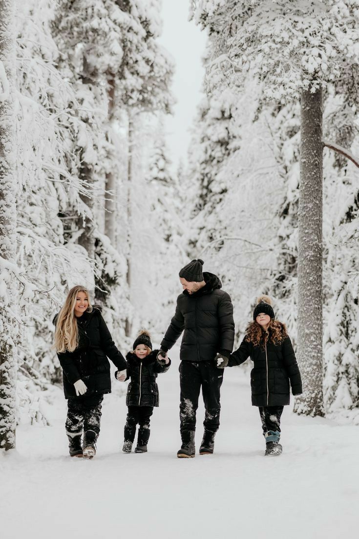 a family walking in the snow holding hands