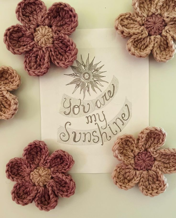 some crocheted flowers and a card with the words you are my sunshine