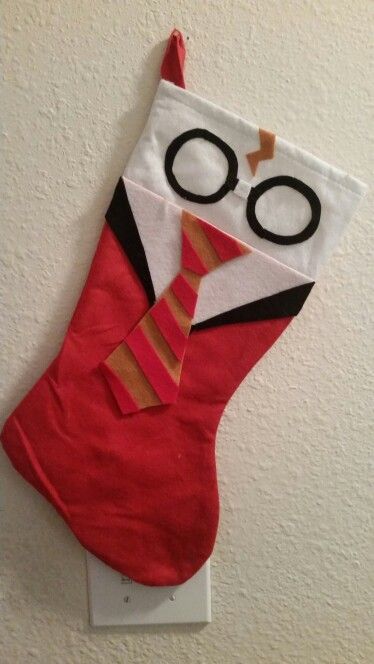 a red christmas stocking with glasses and a tie hanging on the wall next to a white wall