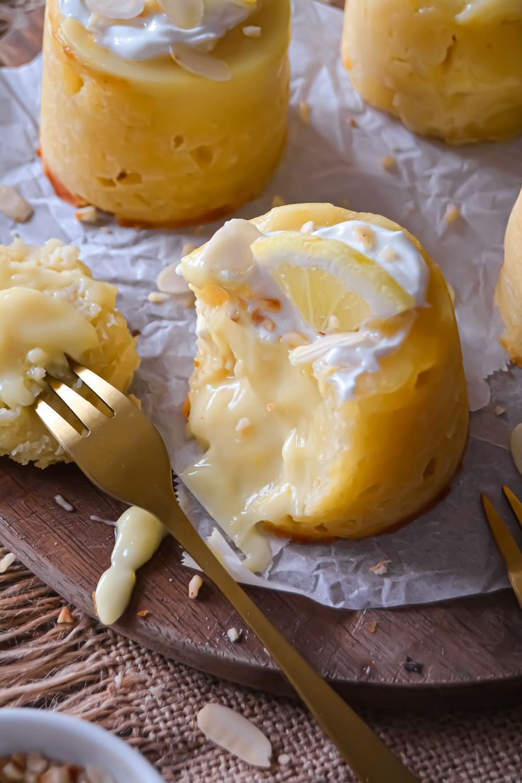 some food is sitting on top of wax paper with a fork next to it and there are lemons in the background