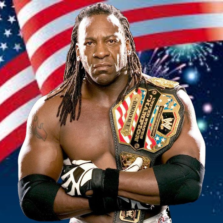 a man with dreadlocks standing in front of an american flag holding a wrestling belt