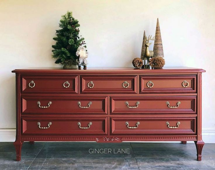 a red dresser with christmas decorations on top