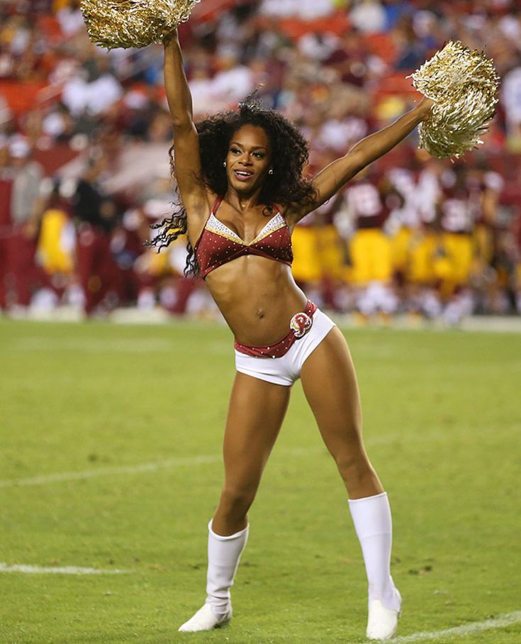 a cheerleader is performing on the field at a football game