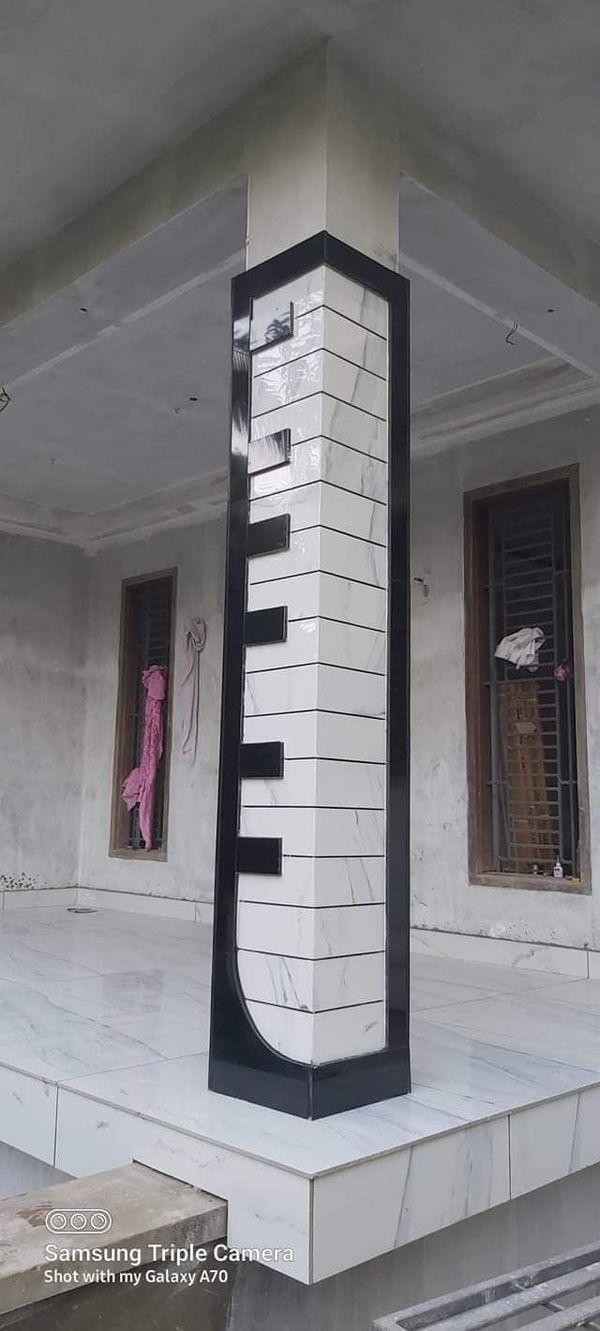 a tall black and white clock tower sitting in the middle of a building next to two windows