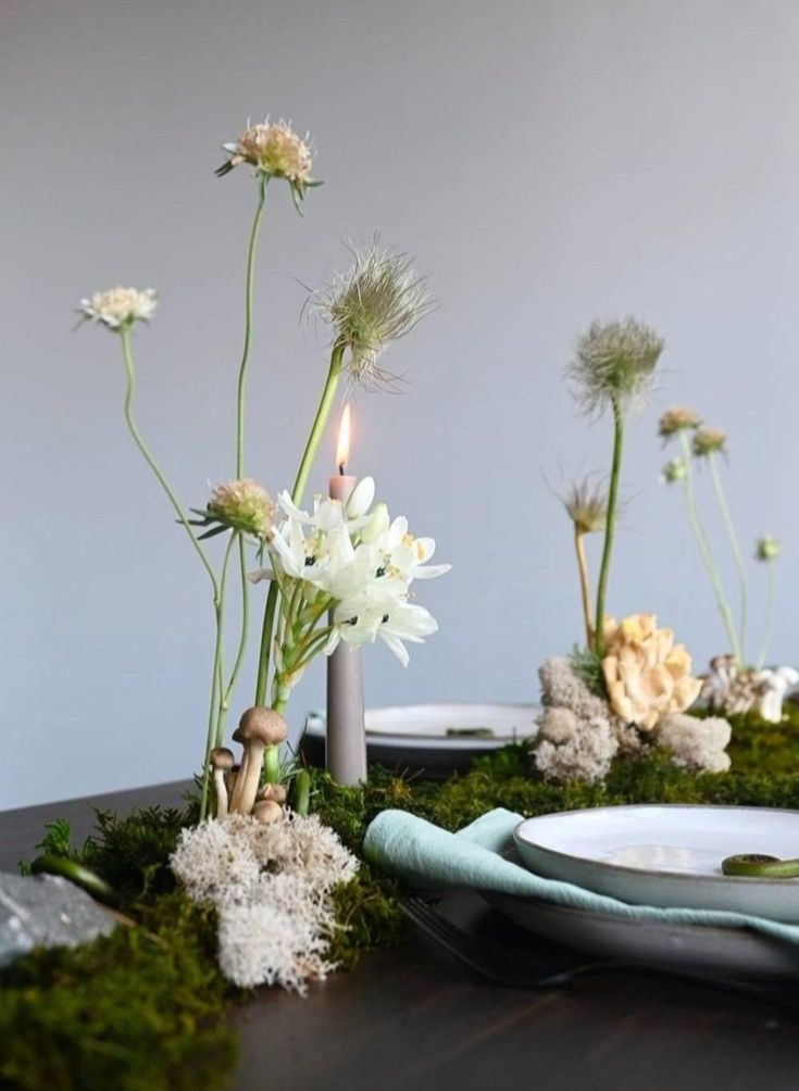 the table is decorated with moss and flowers