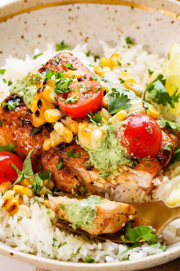 a white bowl filled with rice and chicken covered in avocado garnish