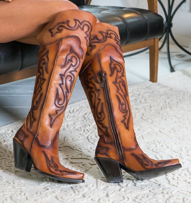 Tall boots make a fashion statement and these babes are 20" of pure classy fashion. Handcrafted of rich leather with an inside zipper for easy on and off. The design is narrow at the ankle and the tall fashion heel makes your legs go forever. Highlighted with an elegant western stitch design and fashion snip toe. They will fast become your favorite night out boots. Get the party started in Dan Post Seductress boots. Leather 20" Height 16" Circumference Leather Lining Ultimate Flex Insole Snip To Knee High Western Boots, Dan Post Boots, Womens Cowgirl Boots, Leather Cowgirl Boots, Buy Boots, Estilo Country, Dan Post, Tall Fashion, Leather Western Boots