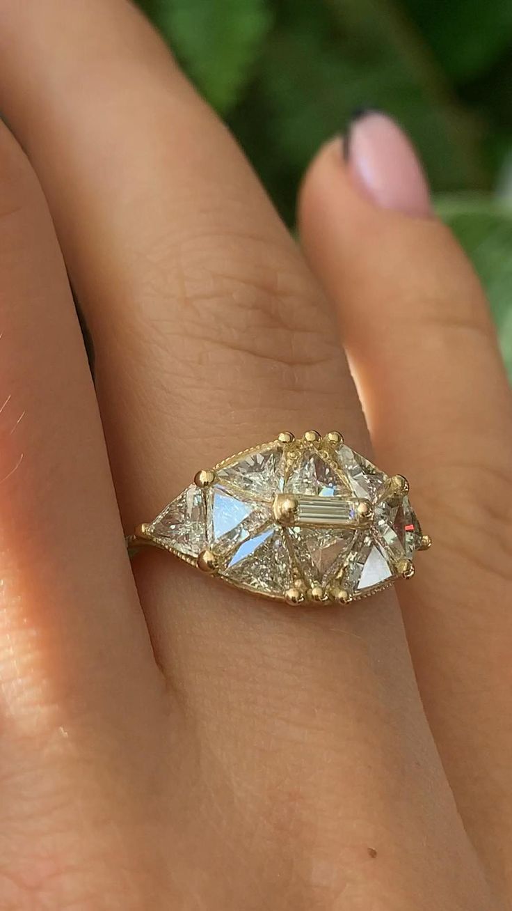 a close up of a person's hand with a diamond ring on their finger