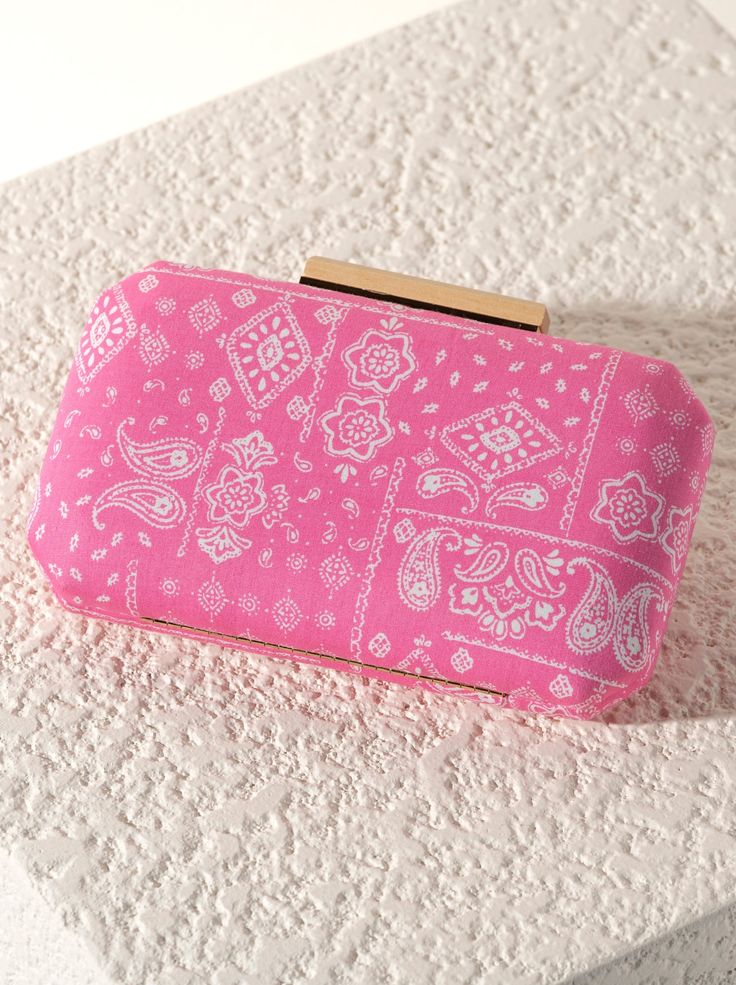 Meet your favorite summer clutch, the Pippa Minaudiere from Shiraleah. This clutch features a fun paisley bandana print and a wooden closure elevating any outfit making it look chic and sophisticated. Measuring 8" x W 2" x H 4.5"; and a 23" L cross body chain , the Pippa Minaudiere Clutch effortlessly exudes style and sets a statement. Pair with other items from the Shiraleah collection to complete your look! Color: Pink L 8" X W 2" X H 4.5"; Hnd 23" Material: Polyester Gold Hardware Detachable Spring Rectangular Clutch, Rectangular Clutch For Spring, Trendy Rectangular Spring Clutch, Trendy Summer Party Clutch, Chic Summer Clutch For Fashion, Trendy Summer Day Out Clutch, Spring Pink Rectangular Clutch, Pink Rectangular Spring Clutch, Pink Rectangular Clutch For Spring