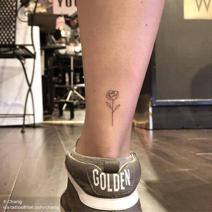 a woman's foot with a small rose tattoo on the left side of her leg