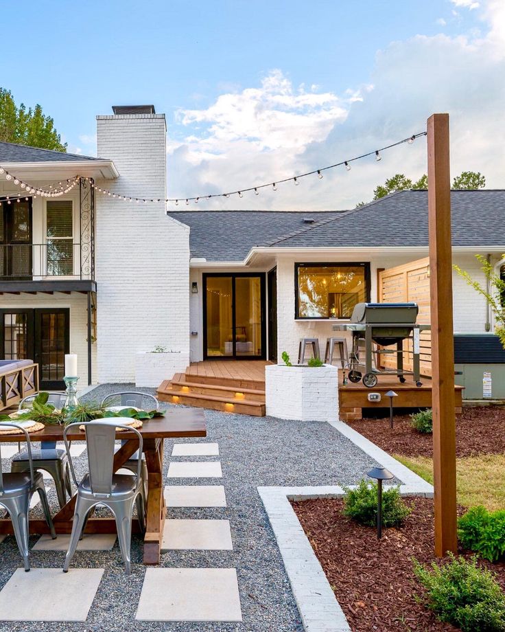 an outdoor patio with table, chairs and grill