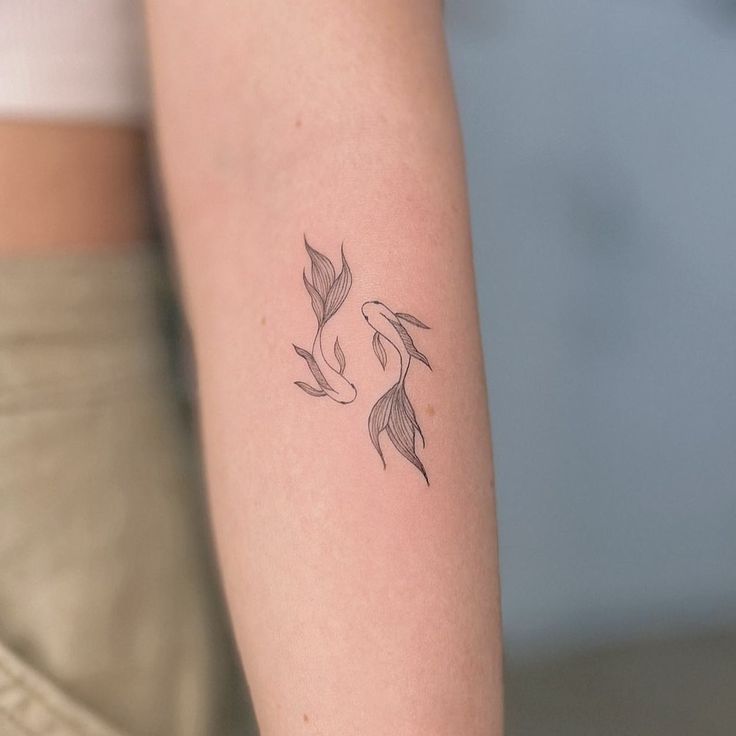 a woman's arm with a small tattoo on the back of her left arm