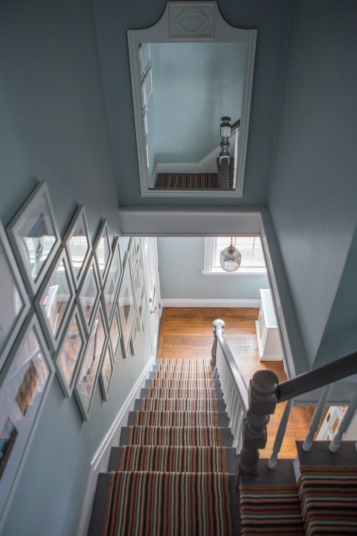 an overhead view of a staircase with pictures on the wall and stairs leading up to it