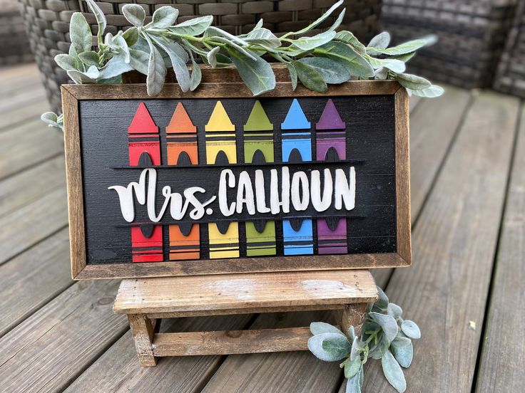 a wooden sign that says mrs cauldon with crayons painted on it