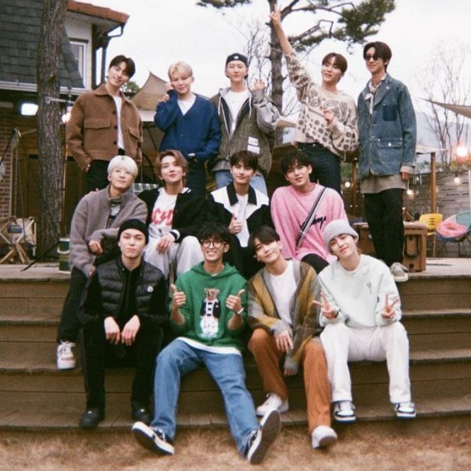 a group of young men sitting on steps in front of a house with one man giving the peace sign