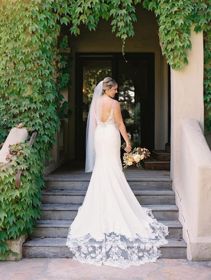 a woman in a wedding dress standing on some steps