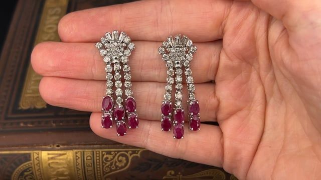 These lovely dangle style pierced earrings are each accented with three (3), prong set, baguette cut diamonds, thirty-three (33), prong set, round brilliant cut diamonds and six (6), prong set, oval mixed cut natural rubies. The earrings measure 42mm X 15mm and are finished with friction style backs. Classic Baguette Diamond Earrings For Formal Occasions, Luxury Baguette Cut Diamond Earrings, Classic Evening Baguette Diamond Earrings, Classic Diamond Chandelier Earrings With Brilliant Cut, Luxury Baguette Cut Diamond Earrings For Formal Occasions, Classic Brilliant Cut Chandelier Earrings For Formal Occasions, Classic Chandelier Earrings With Brilliant Cut For Formal Occasions, Luxury Formal Baguette Cut Diamond Earrings, Classic Diamond Chandelier Earrings With Diamond Accents