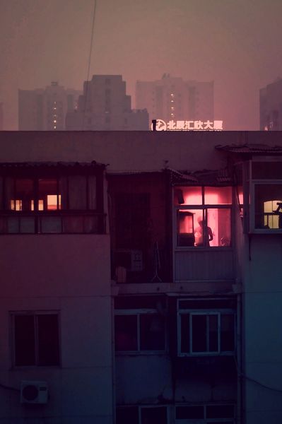 an apartment building with the city lights on in the backround at night time