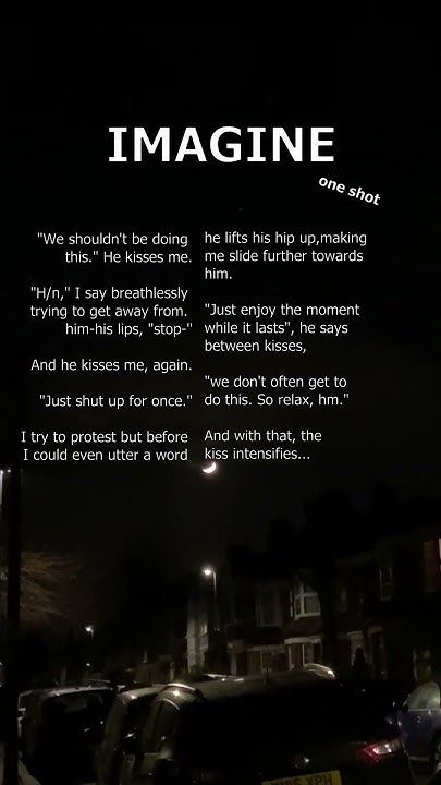 a poem written on the side of a building in front of parked cars at night