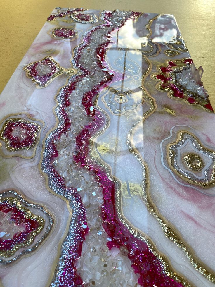 the table is covered with pink and white marbles, gold accents, and sequins