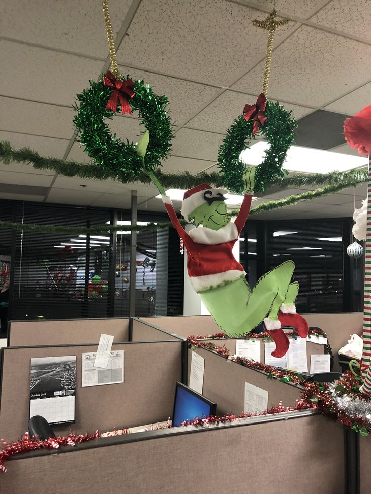 an office cubicle decorated for christmas with decorations and wreaths hanging from the ceiling