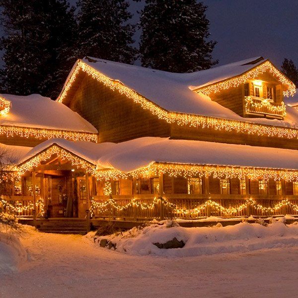 a house covered in christmas lights and snow