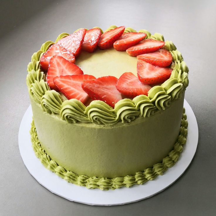 a cake with green icing and strawberries on top