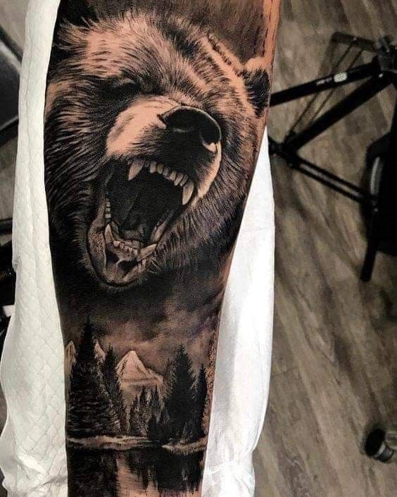 a man with a bear tattoo on his arm and shoulder, showing it's teeth