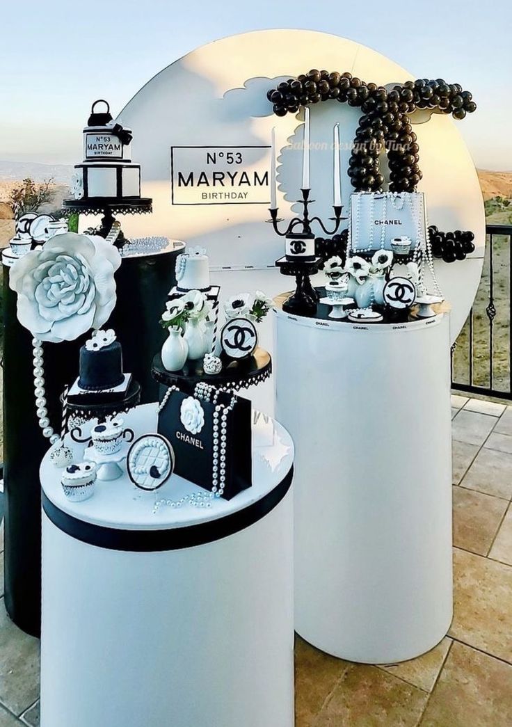 two large white vases with black and white decorations on top of them, sitting next to each other