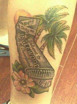 a tattoo on the leg of a person with a palm tree and an open book