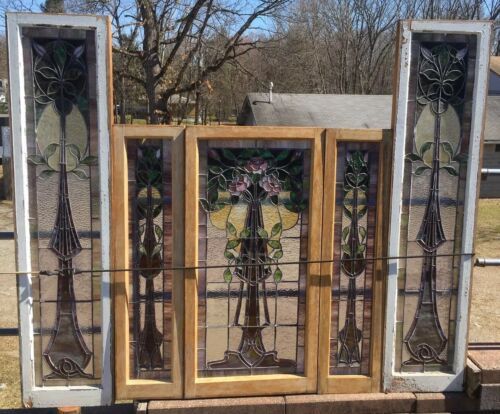 two stained glass doors sitting next to each other in front of a fenced area