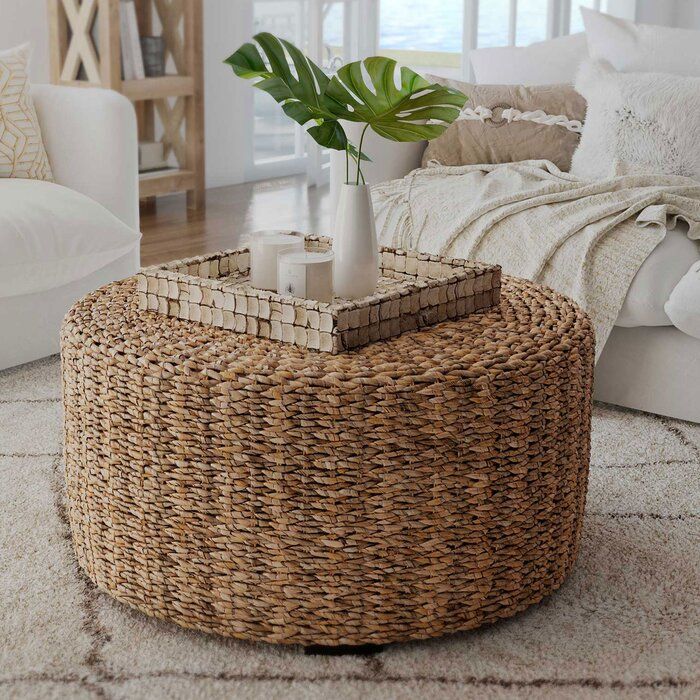 a wicker coffee table with a plant in it