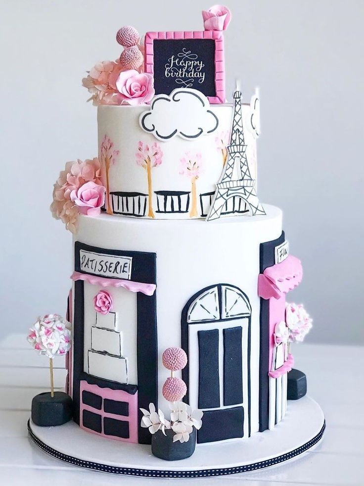 a three tiered cake is decorated with pink and black decorations, including the eiffel tower