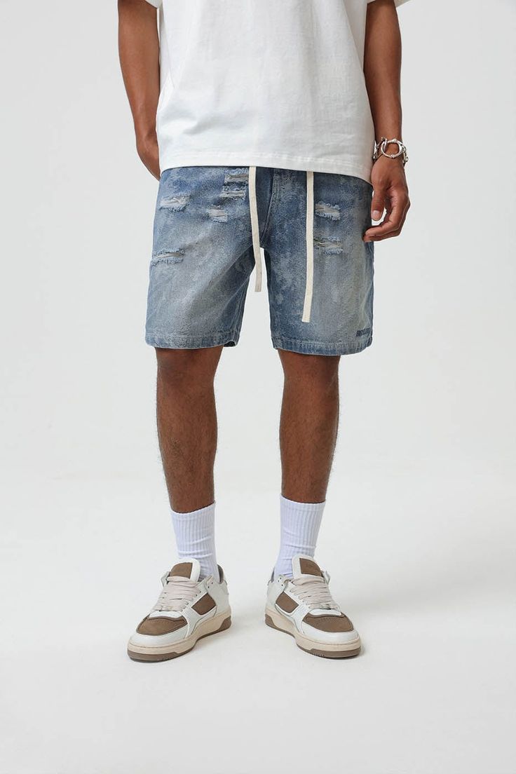 Bring an edgy touch to your casual wear with the Contrast Texture Ripped Denim Shorts. This pair is thoughtfully ripped throughout, adding a grungy twist to the classic washed blue color. With an elastic waistband design, which is highly unusual for denim shorts, you get the benefit of both style and comfort. The extended drawstrings allow for a customizable fit, adding to the unique appeal of these must-have shorts. Ripped throughout for a grungy aesthetic Classic washed blue color Elastic wais Urban Style Ripped Medium Wash Bottoms, Ripped Cotton Bottoms In Washed Blue, Faded Ripped Cotton Jean Shorts, Faded Cotton Ripped Jean Shorts, Ripped Light Wash Recycled Denim Bottoms, Light Wash Ripped Recycled Denim Bottoms, Distressed Rugged Bottoms With Relaxed Fit, Relaxed Fit Distressed Medium Wash Jean Shorts, Distressed Medium Wash Jean Shorts, Relaxed Fit