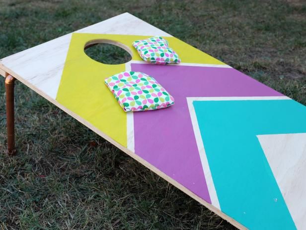 a colorful board game sitting on top of a grass covered field next to a wooden table