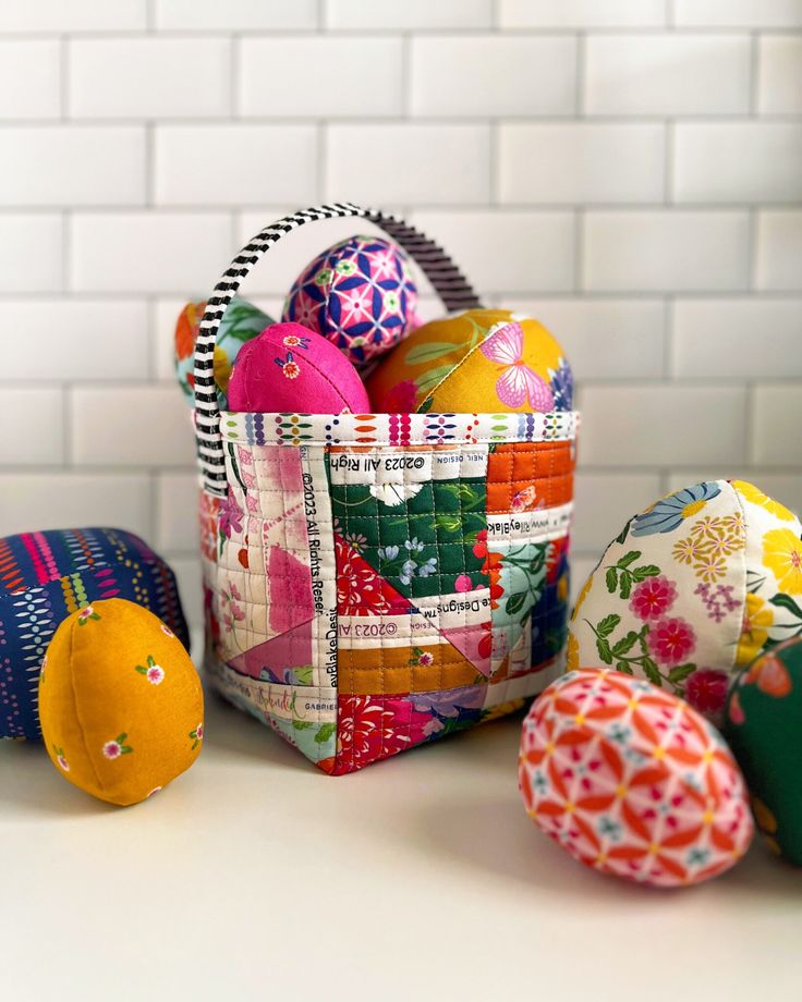 an easter basket filled with painted eggs on a counter top next to other decorative items