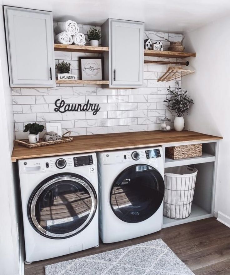 a washer and dryer in a small room with white tile on the walls