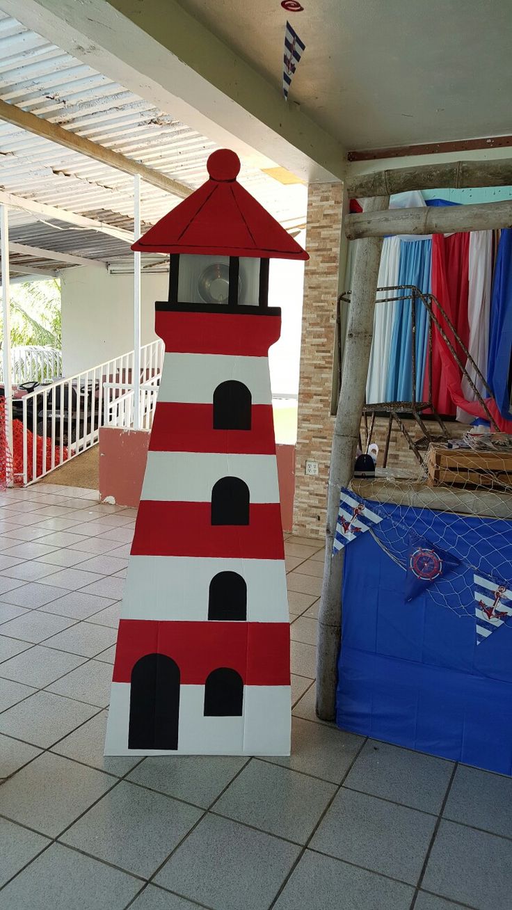 a red and white lighthouse made out of cardboard