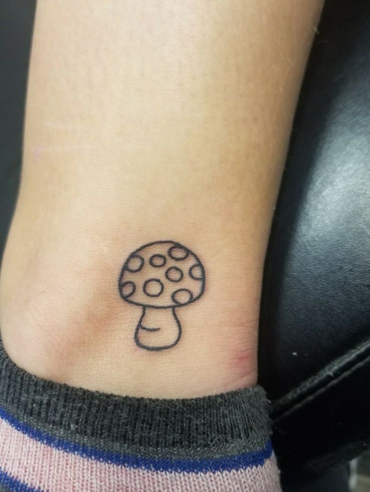 a small mushroom tattoo on the ankle